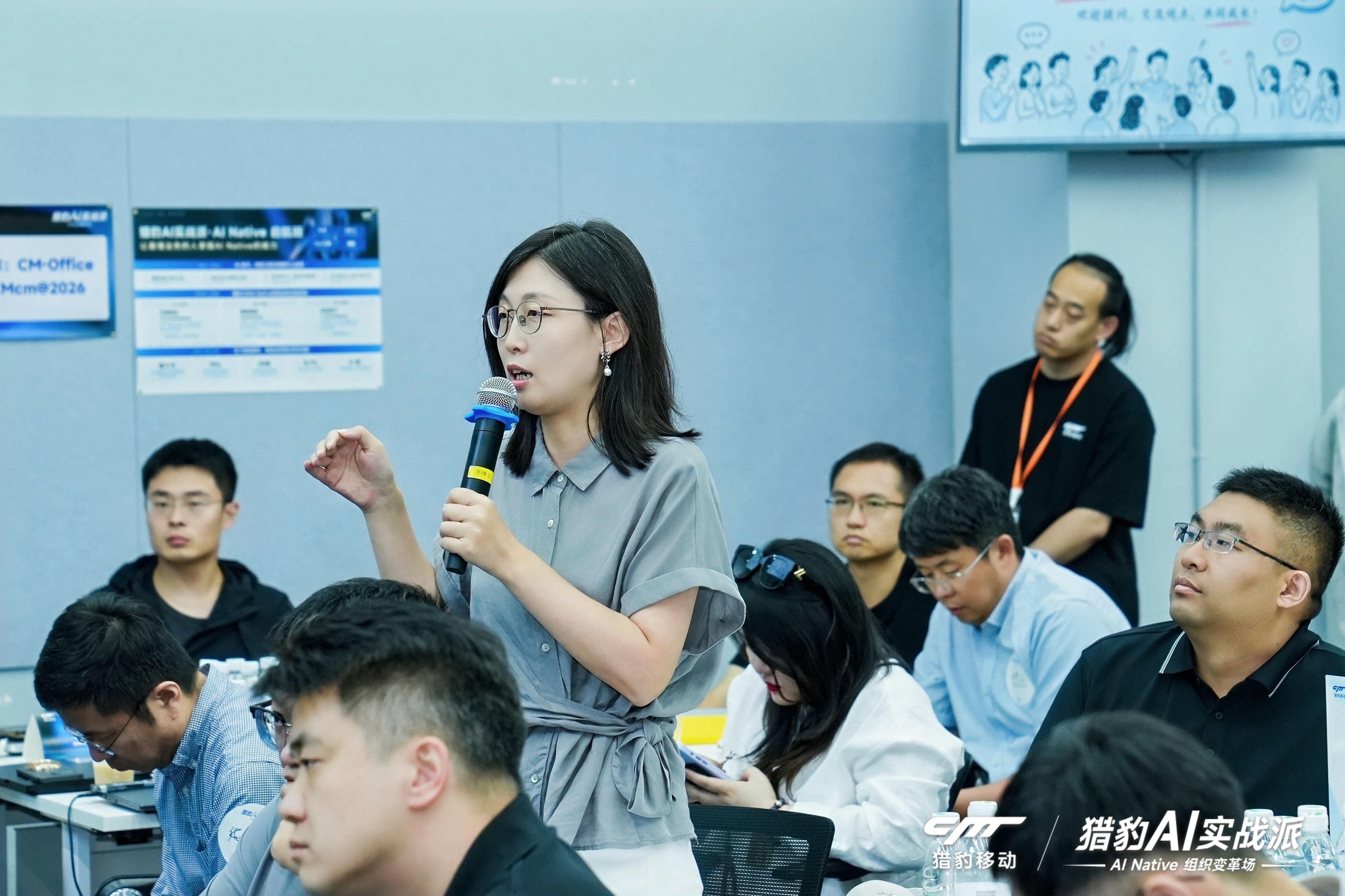 参与者手持麦克风现场提问